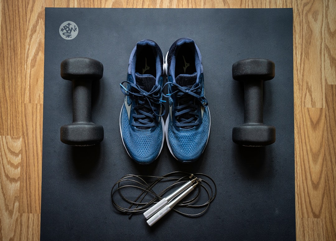 A well-organized home gym with various fitness equipment like dumbbells, a yoga mat, and resistance bands in a cozy space.
