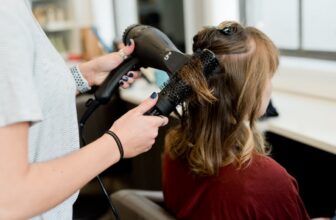 A variety of hair styling tools including brushes, straighteners, and dryers arranged aesthetically on a countertop.