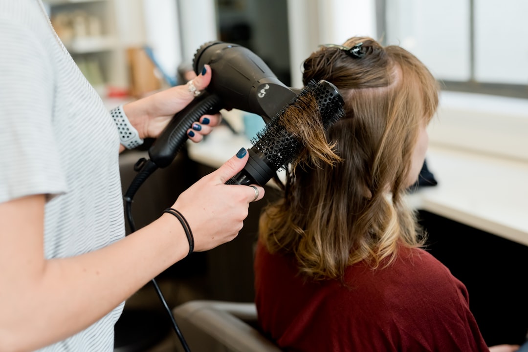 A variety of hair styling tools including brushes, straighteners, and dryers arranged aesthetically on a countertop.