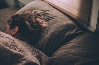 A serene bedroom setting with soft lighting, featuring a cozy bed with fluffy pillows and a calming atmosphere, promoting relaxation and restful sleep.